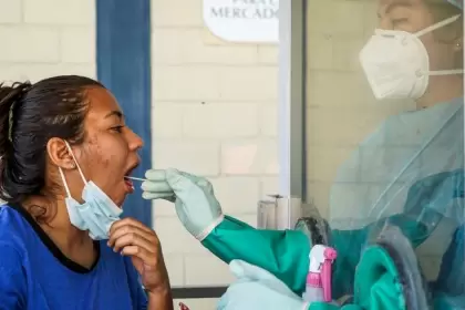 Un trabajador de la salud tomando una muestra de PCR de un paciente en un sitio de prueba en El Salvador.