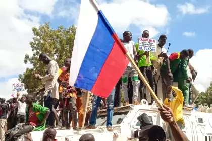 Con una bandera rusa ondeando, los manifestantes golpistas se paran encima de un vehículo blindado de la ONU en Uagadugú, Burkina Faso.