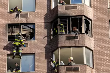 Los bomberos realizan un rescate con cuerdas después de que estalló un incendio dentro de un edificio de gran altura en Manhattan