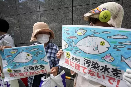 Los manifestantes sostienen carteles que dicen "¡No arrojen agua contaminada radiactiva al mar!"