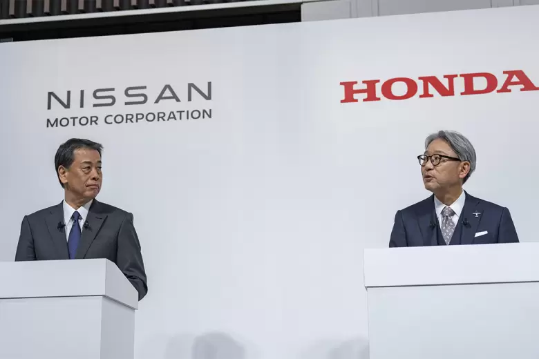 Toshihiro Mibe de Honda habla y Makoto Uchida de Nissan, escucha.