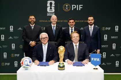 Representantes de la FIFA y del fondo soberano saudí PIF posan junto a la Copa del Mundo tras oficializar su nuevo acuerdo