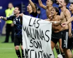 Los jugadores de la selección celebran con una bandera de las islas Malvinas